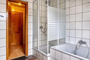 a bathroom with a tub and a walk in shower at Ferienwohnung Klee in Fedderwarden +15 photos