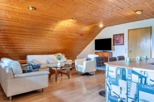 a living room with white furniture and a wooden ceiling at Ferienwohnung Klee in Fedderwarden