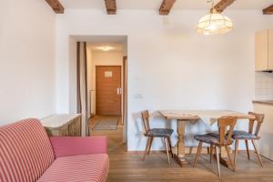 a living room with a table and chairs and a couch at Sabina Dolomites Compatsch in Alpe di Siusi