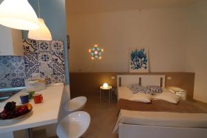 a bedroom with a bed and a table with a bowl of fruit at Casa Vacanze Maya a Otranto in Otranto +25 photos