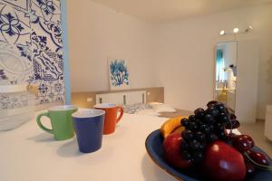 a table with cups and a bowl of fruit on it at Casa Vacanze Maya a Otranto in Otranto