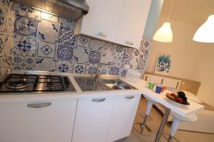 a white kitchen with a sink and a stove at Casa Vacanze Maya a Otranto in Otranto