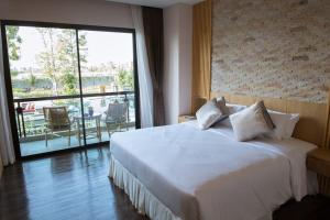 a bedroom with a white bed and a large window at North Hill City Resort in Hang Dong