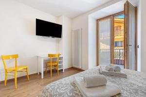 a bedroom with a bed and a desk and a television at Appartamento Lesivèra in Saone