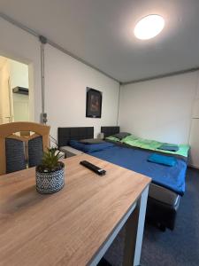 a room with two beds and a wooden table at Menzel Appartment W1 in Beckingen
