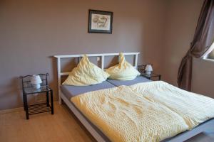 a bedroom with a bed with yellow sheets and pillows at Ferienwohnung Maintalblick in Eltmann
