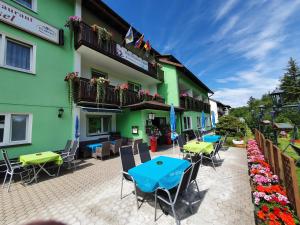 an outdoor patio with tables and chairs in front of a building at Gruppenferienhaus Dressel in Warmensteinach +22 photos