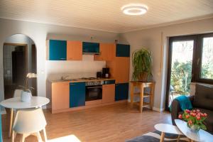 a kitchen with blue and orange cabinets and a table at Ferienwohnung Maintalblick in Eltmann