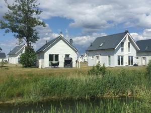 a white house with a black roof at Skipper Hus by Seeblick Ferien in Olpenitz
