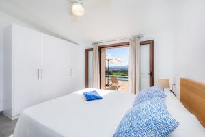 a white bedroom with a bed and a sliding glass door at Can Jaume in Manacor +18 photos