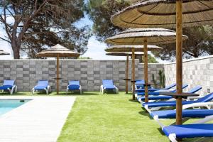 a row of chairs and umbrellas next to a pool at Casa Torre De Meca 2 Shared Pool in Los Caños de Meca