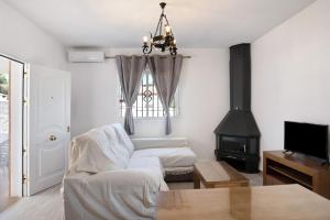 a living room with a couch and a stove at Casa Torre De Meca 2 Shared Pool in Los Caños de Meca