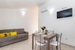 ein Wohnzimmer mit einem Tisch und einem Sofa in der Unterkunft Casa Angus in Badesi