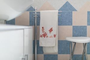 ein Badezimmer mit einem Handtuch, das an einem Handtuchhalter hängt in der Unterkunft Casa Angus in Badesi + 22 Fotos