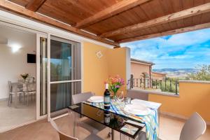 ein Esszimmer mit Tisch und Stühlen und einem Balkon in der Unterkunft Casa Angus in Badesi