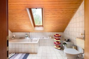 a bathroom with a tub and a toilet and a sink at Ferienwohnung Kudensee in Kudensee +15 photos