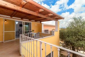 ein Balkon eines Hauses mit einer hölzernen Pergola in der Unterkunft Casa Angus in Badesi