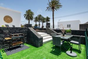 a backyard with a table and chairs and a grill at Villa Tahoyo in Máguez
