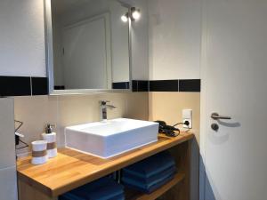 a bathroom with a white sink and a mirror at Waldmomente in Schauren