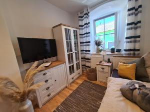 a living room with a flat screen tv on a dresser at Haus Waldstein Kraxler Single in Weißenstadt