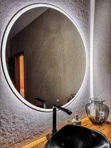 a bathroom sink with a large round mirror above it at Amber loft 12 Rusnė in Rusnė +16 photos