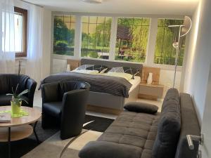 a living room with a bed and a couch at Ferienwohnung Palmengarten in Lichtenstein