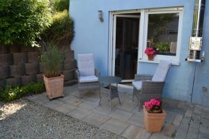 a patio with chairs and a table in front of a house at Komfort-Apartment Mit Terrasse in Estenfeld