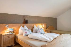 a bedroom with a bed with white sheets and pillows at Woehrmannhof Apt Birnblüte in Feldthurns
