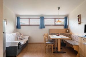 a living room with a table and a couch at Woehrmannhof Apt Birnblüte in Feldthurns