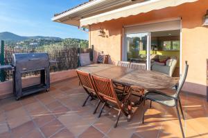 a patio with a table and chairs and a grill at Casa con piscina in Calonge