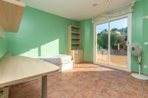 a room with a bedroom with green walls and a window at Casa con piscina in Calonge +20 photos