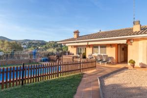 a house with a fence and chairs in the yard at Casa con piscina in Calonge
