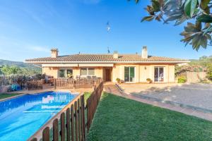 a villa with a swimming pool in front of a house at Casa con piscina in Calonge