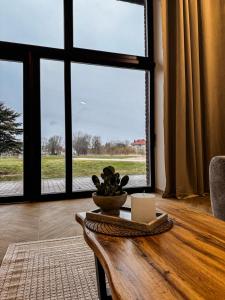 a living room with a table and a large window at Amber loft 12 Rusnė in Rusnė