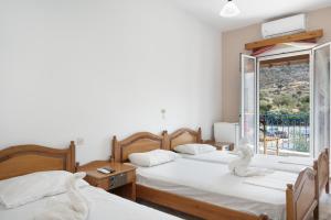 a room with three beds and a window at Hotel Galini in Kalymnos
