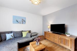a living room with a couch and a flat screen tv at Fewo im sonnigen Kaiserstuhl in Endingen