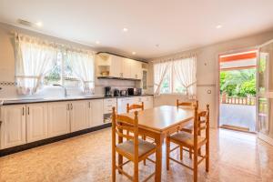 a kitchen with a wooden table and chairs and a dining room at Luna Azul in Sant Jordi