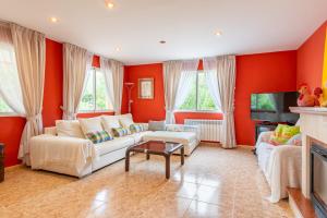 a living room with orange walls and a white couch at Luna Azul in Sant Jordi +17 photos