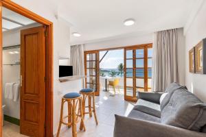a living room with a couch and a table with chairs at Playa Delphin 306 in Puerto Naos