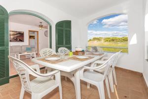 a dining room with a white table and chairs at White sands 613 in Arenal d'en Castell