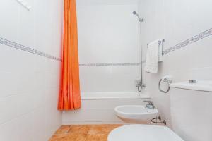 an orange shower curtain in a bathroom with a toilet at White sands 613 in Arenal d'en Castell +17 photos