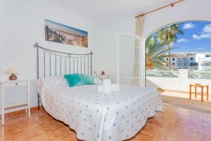 a bedroom with a bed and a large window at White sands 613 in Arenal d'en Castell