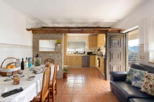 a kitchen and living room with a table and a couch at Casa De Santo Amaro in Carrazedo