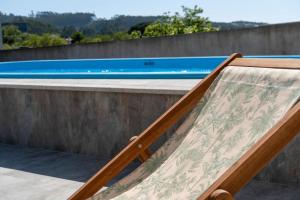 a wooden bed next to a swimming pool at Casa De Santo Amaro in Carrazedo
