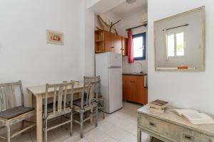 a kitchen with a table and a white refrigerator at Perasma Studios 9 in Kipri +14 photos