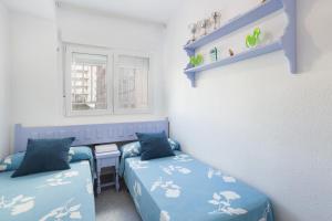 ein Zimmer mit zwei Betten und einem Fenster in der Unterkunft Ca Llaurí in Daimús