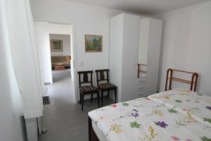 a bedroom with a bed and two chairs at Ferienwohnung Im Schiller in Wiesenbronn