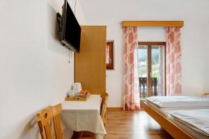a room with a table and a bed and a television at Harmony room in Piano