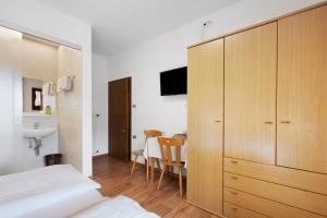 a bedroom with a large wooden cabinet and a table at Harmony room in Piano