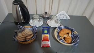 a table with a basket of bread and a coffee maker at Hostal AMALAYA in Salta